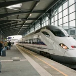 TGV moderne entrant en gare en France avec des voyageurs sur le quai, illustrant les dernières innovations du transport ferroviaire
